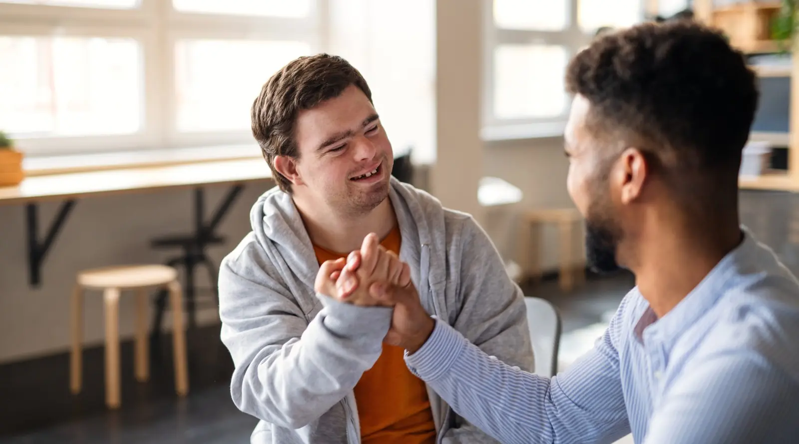 Young man laughing with his support worker