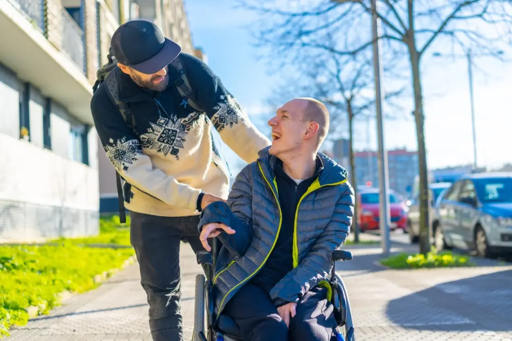Person in a wheelchair laughing with a friend